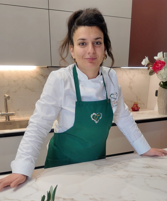 Mani dello chef impiattano, piatto elegante, dettaglio salsa.